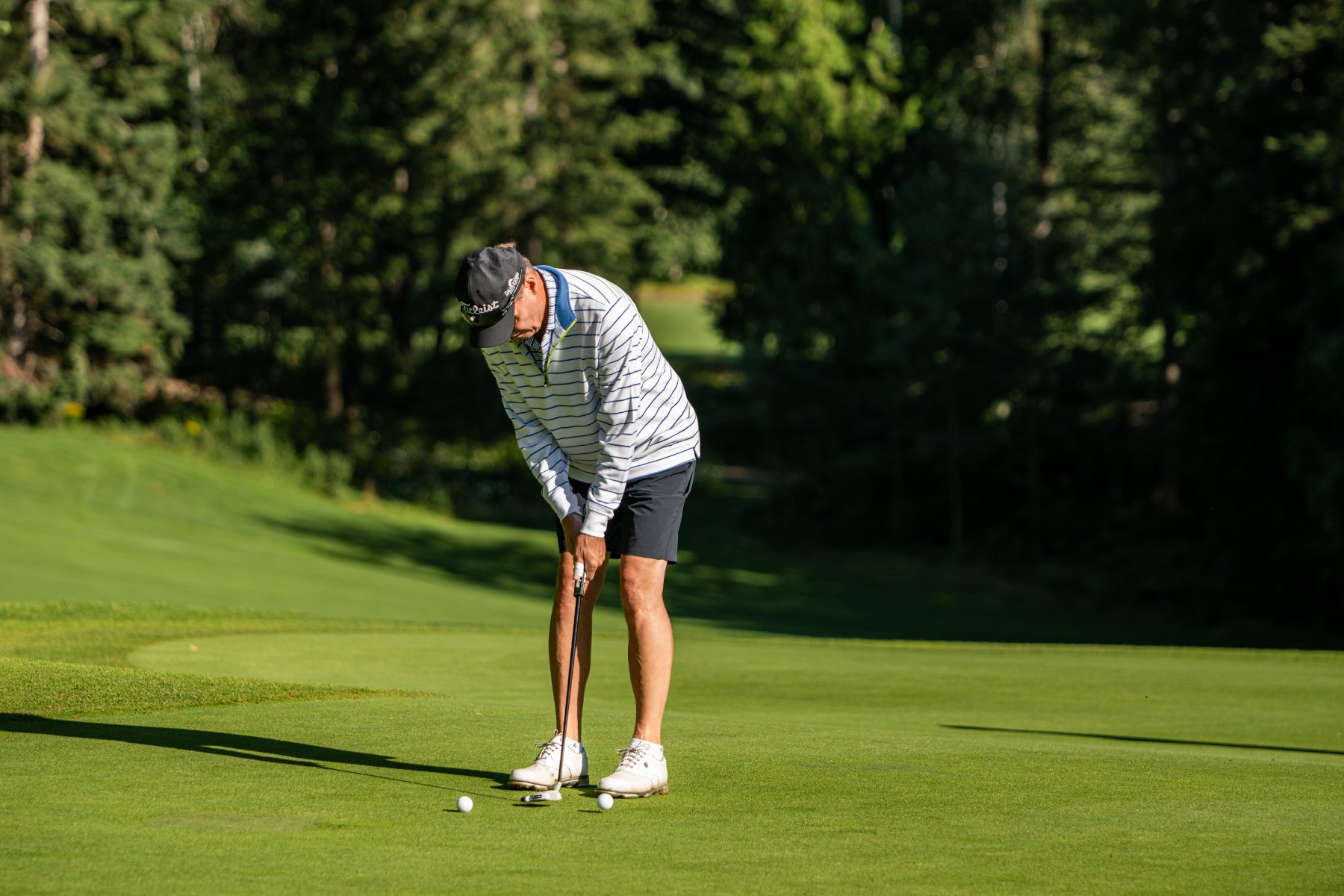 A golfer mid-swing on a Shuswap course