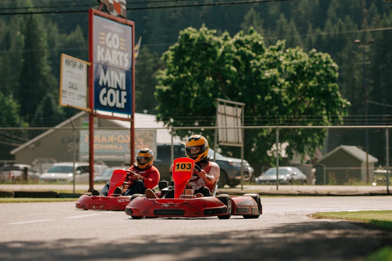 Racing go-karts past the sign at Salmon Arm Go-Karts & Mini-Golf